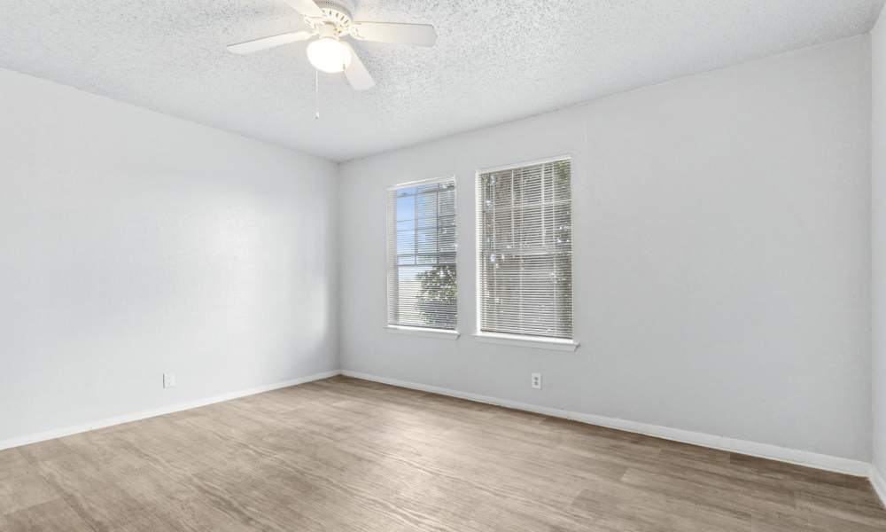 Apartment bedroom with windows at Arbors of Taylor in Taylor, Texas