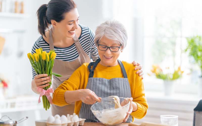 Happy resident mixing dough with her daughter at Grand Villa of Port Charlotte in Port Charlotte, Florida