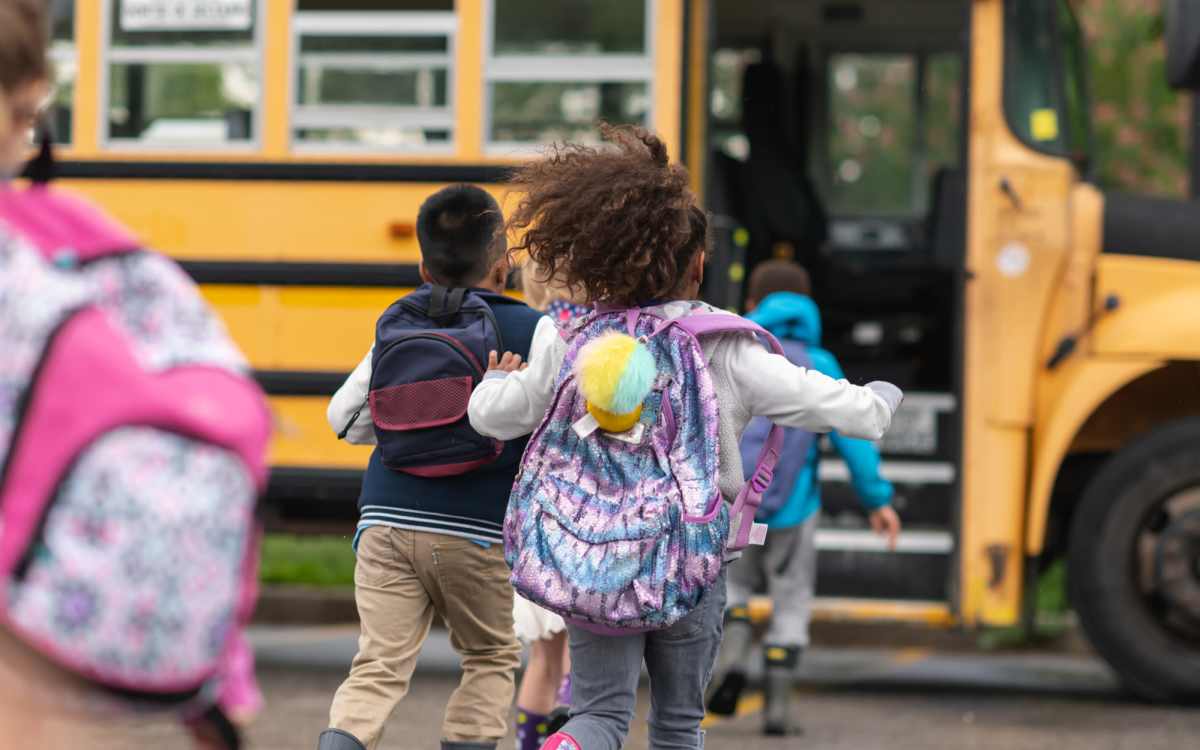 Kids running to board school bus at Chesapeake Landing Apartments in Landover Hills, Maryland