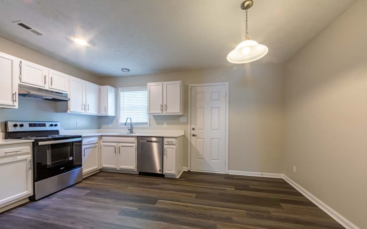 Stainless steel appliances with hard wood flooring of an apartment at Cape Fear Townhomes in Fayetteville, North Carolina
