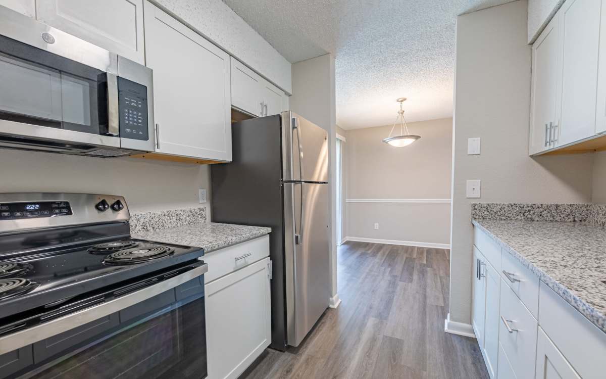Spacious kitchen with wood-style flooring at Huffman Mill Townhomes in Burlington, North Carolina