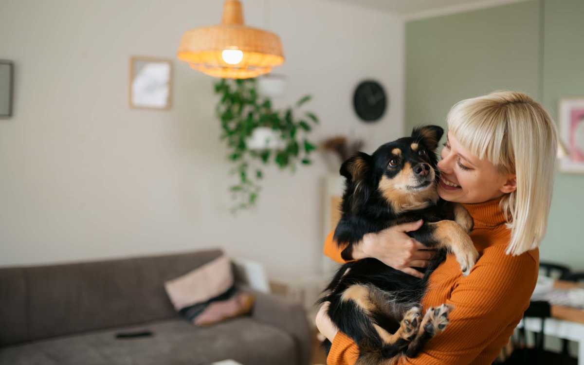 Resident with her pet in living room at Aden Crest in Fort Worth, Texas