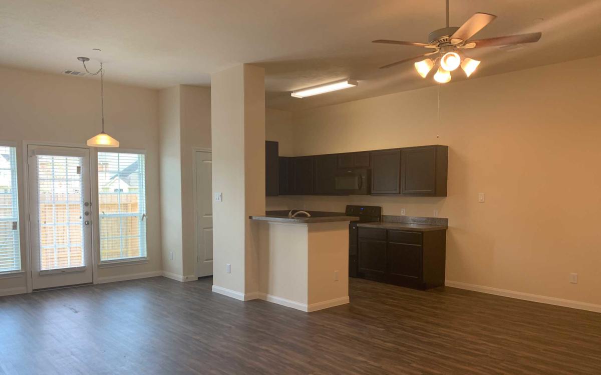 Open living area with kitchen and patio doors at 36 Palms Townhomes in Missouri City, Texas