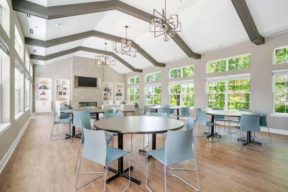 Bright community lounge with large windows, wood-style flooring, and modern seating arrangements at Crestwood Manor in Frederick, Maryland