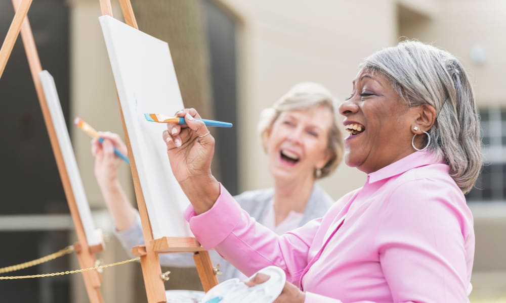 Two residents outside painting at a Randall Residence community