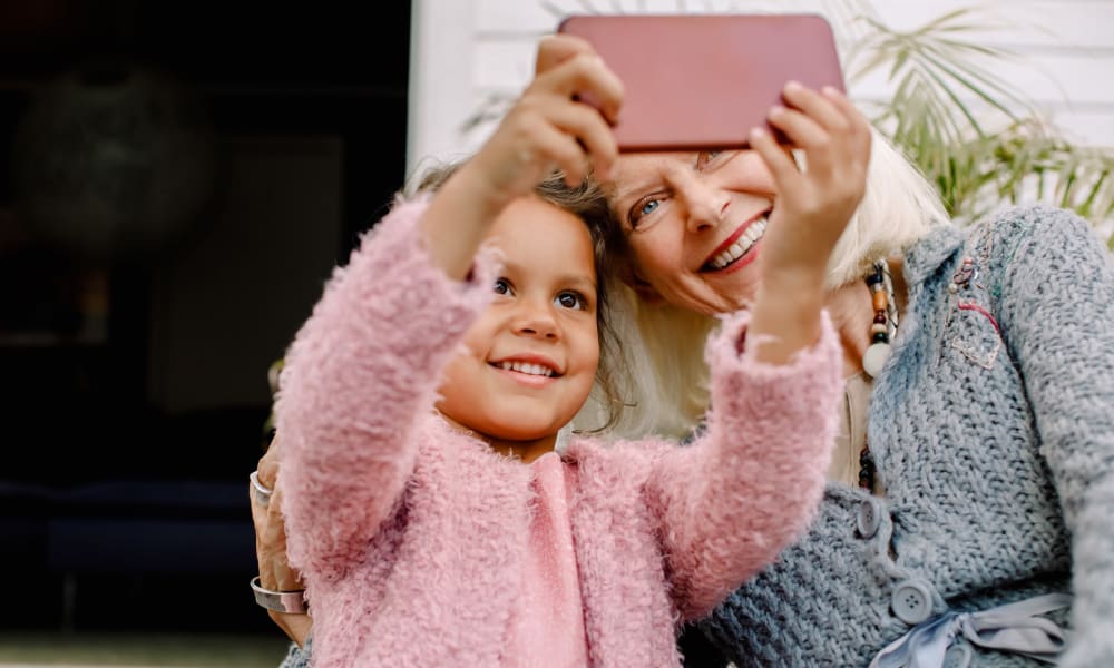 Resident and grandaughter taking a selfie at a community by Cascade Senior Living Services