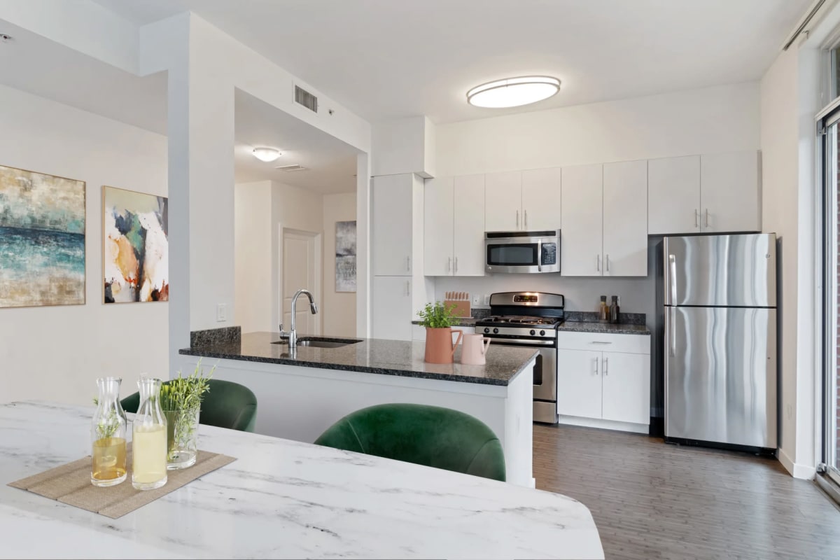 Stainless-steel appliances and wood-style flooring in an apartment at Postmark Apartments in Stamford, Connecticut