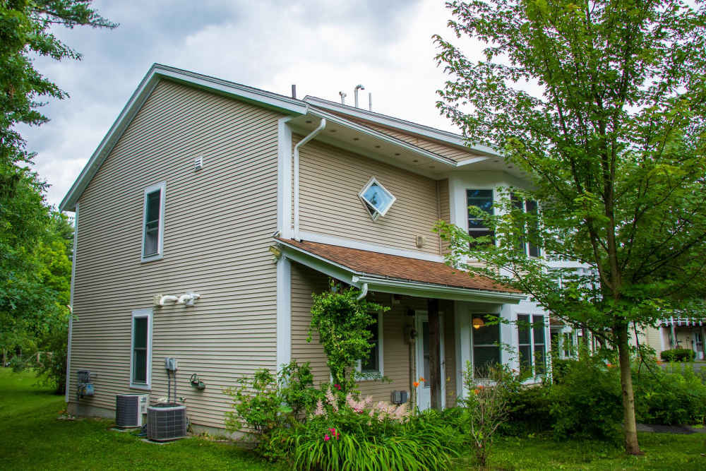 Exterior view of the building showcasing windows and the walkway at Pomeroy Lane Cooperative in Amherst, Massachusetts