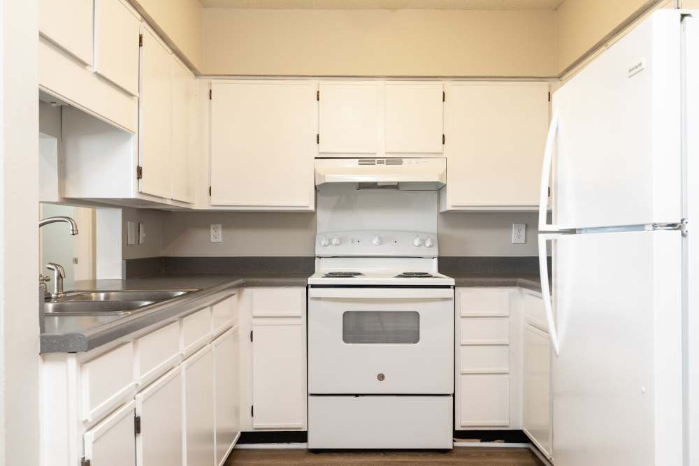 Modern kitchen with white appliances and white wood cabinet at West Village Apartments in Hillsborough, North Carolina
