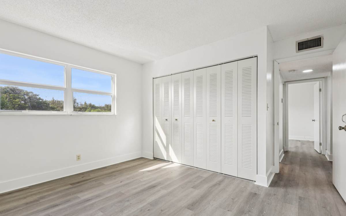 Bedroom with spacious closets at El Jardin Apartments in Hollywood, Florida