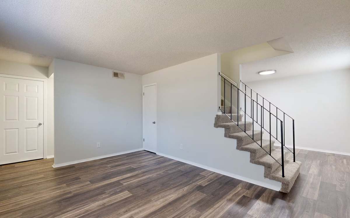 Unfurnished living area with staircase access to upper level at Wynwood at Fairhope in Fairhope, Alabama