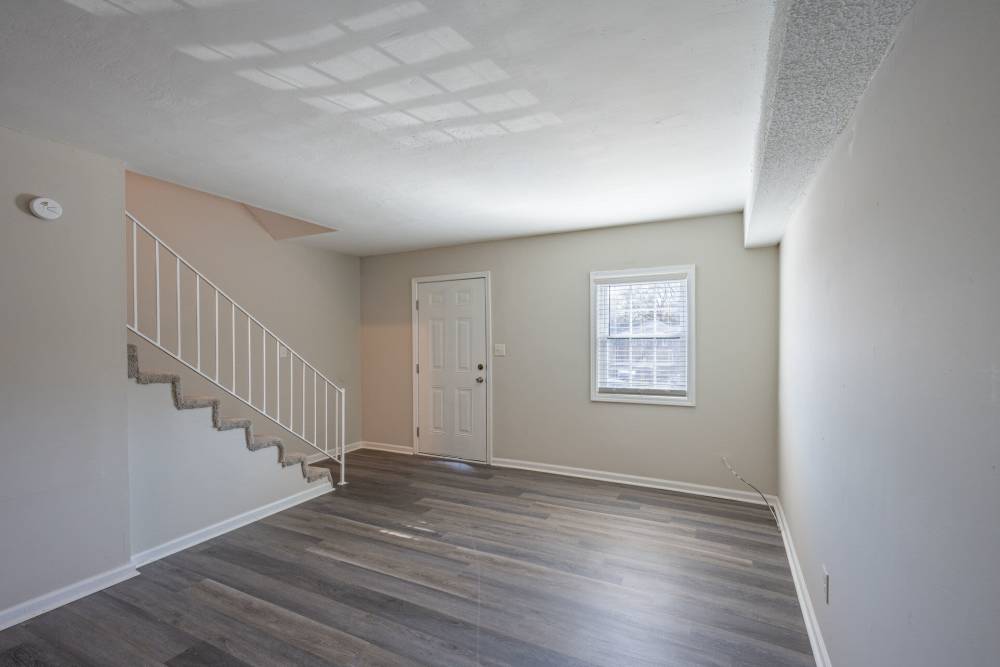 Unfurnished living room with window and wooden flooring at Ivey Ridge Apartments in Graham, North Carolina
