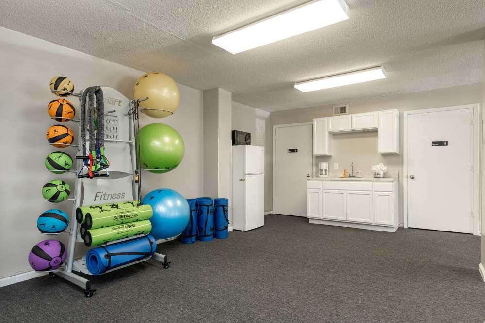 Fitness center with carpet flooring at West Village Apartments in Hillsborough, North Carolina