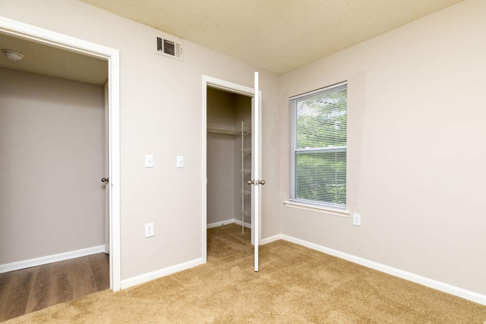 Unfurnished bedroom with carpet flooring and closet at West Village Apartments in Hillsborough, North Carolina