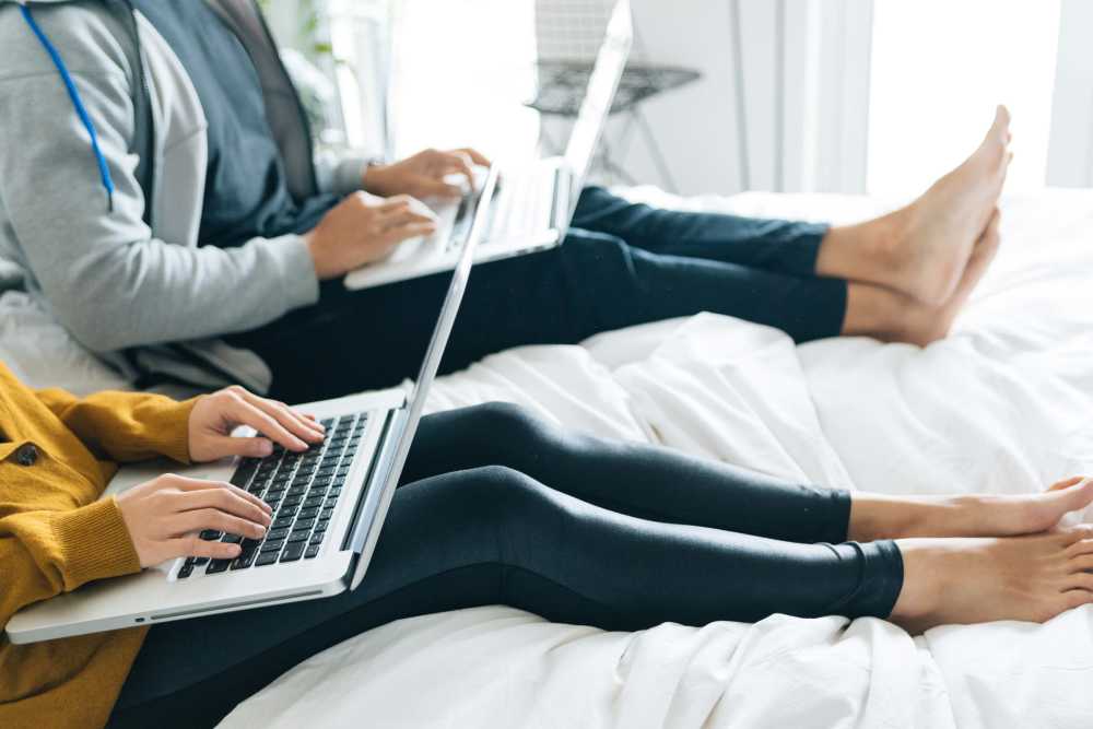 Residents sitting on bed using laptops at Stonecrest Apartments in Spokane, Washington