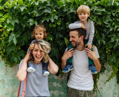 Happy family posing for a photo outside at Winding Creek Apartments in Webster, New York