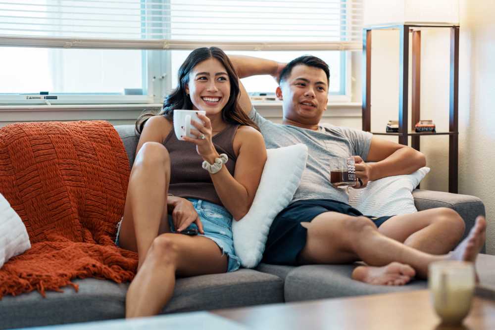 Couple relaxing on a couch at Dolphin Bay Apartments in Hilo, Hawaii