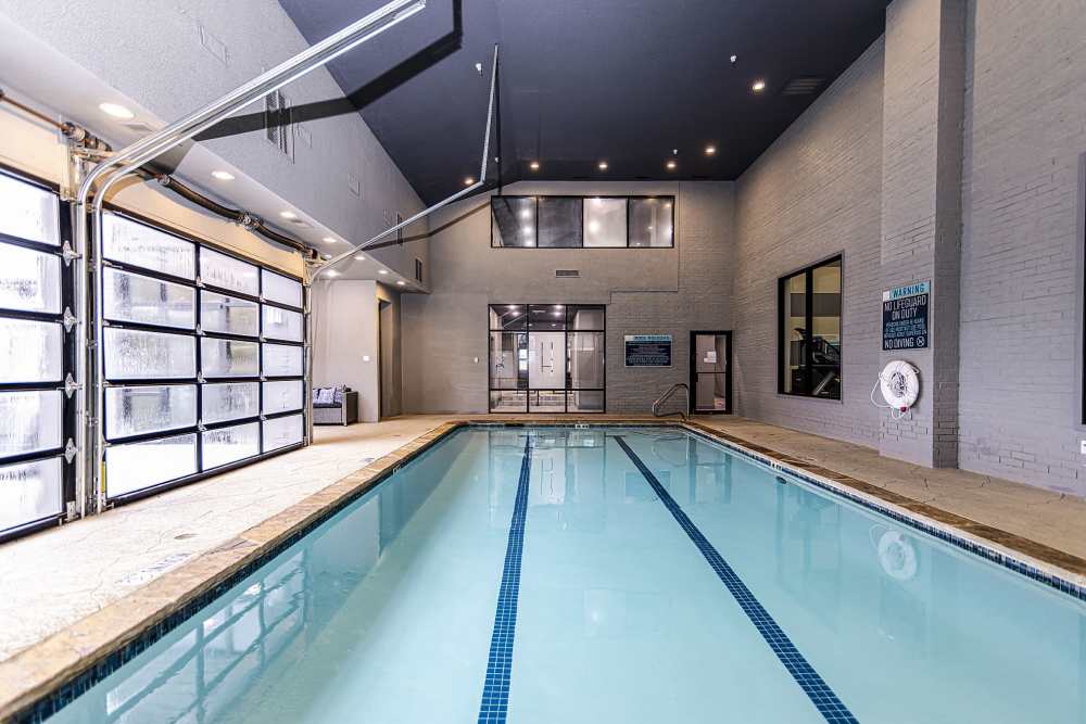 Indoor swimming pool with clear blue water at Halston in Dallas, Texas