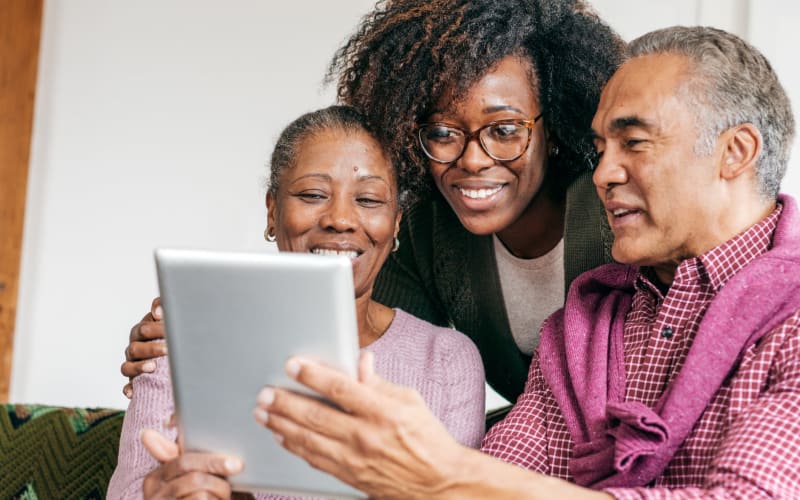 Resident couple using a tablet computer with help from a younger family member at Blossom Ridge in Oakland Charter Township, Michigan