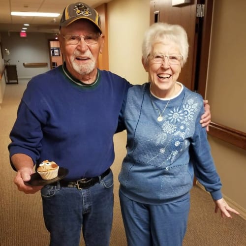 resident couple arm-in-arm walking the hallways at The Oxford Grand Assisted Living & Memory Care in Wichita, Kansas