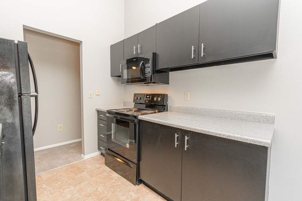 Kitchen with black appliances and granite countertop at Waterford Manors in Manchester, Missouri
