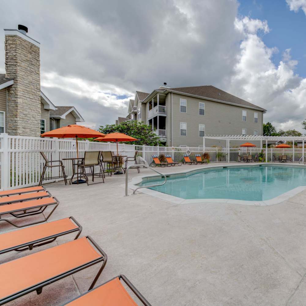 Charming pool area with inviting lounge chairs and vibrant umbrellas at Boulder Springs in Maryland Heights, Missouri.