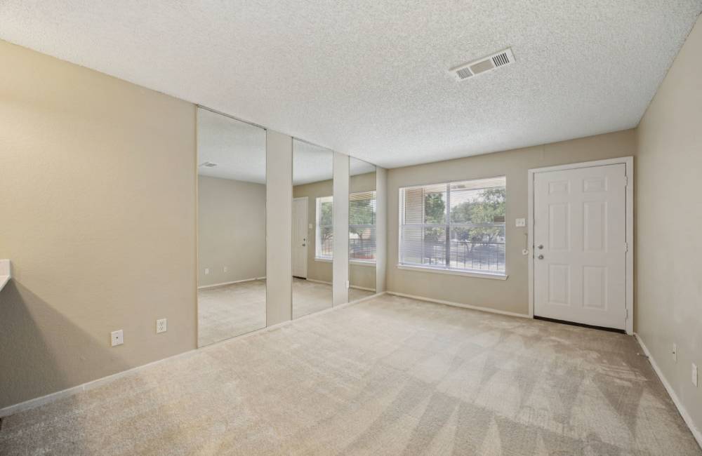 Living room with patio access at Shadow Brook Apartments in Arlington, Texas
