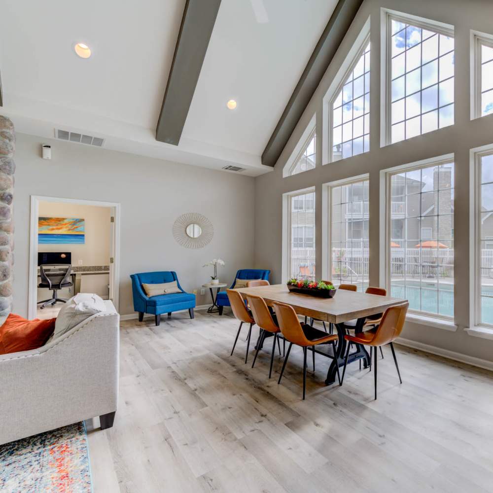 Bright and inviting dining area with large windows overlooking a sparkling water pool at Boulder Springs in Maryland Heights, Missouri.