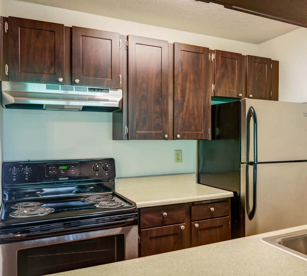 Modern kitchen with wooden cabinets and granite countertops at Ansley Murrayhill in Tigard, Oregon