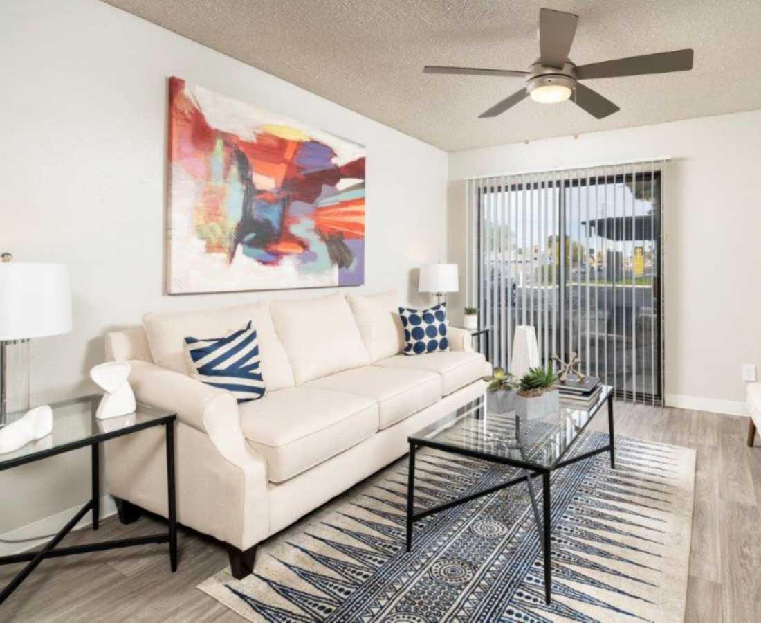 Modern living room with ceiling fan and built-in window coverings at Sunpointe in Phoenix, Arizona