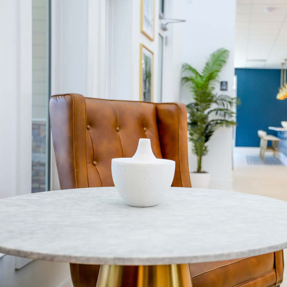 Stylish lounge with modern decor and greenery at The Apartments At Kelton Station in Williamsburg, Virginia