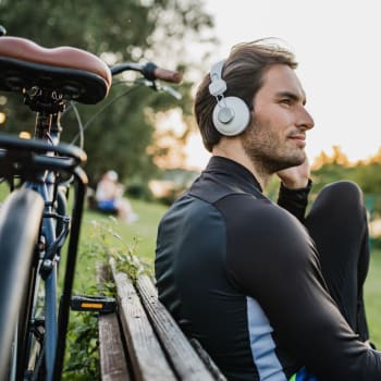 Man with headphones taking a break from a bike ride near Adobe Lake Apartments in Concord, California