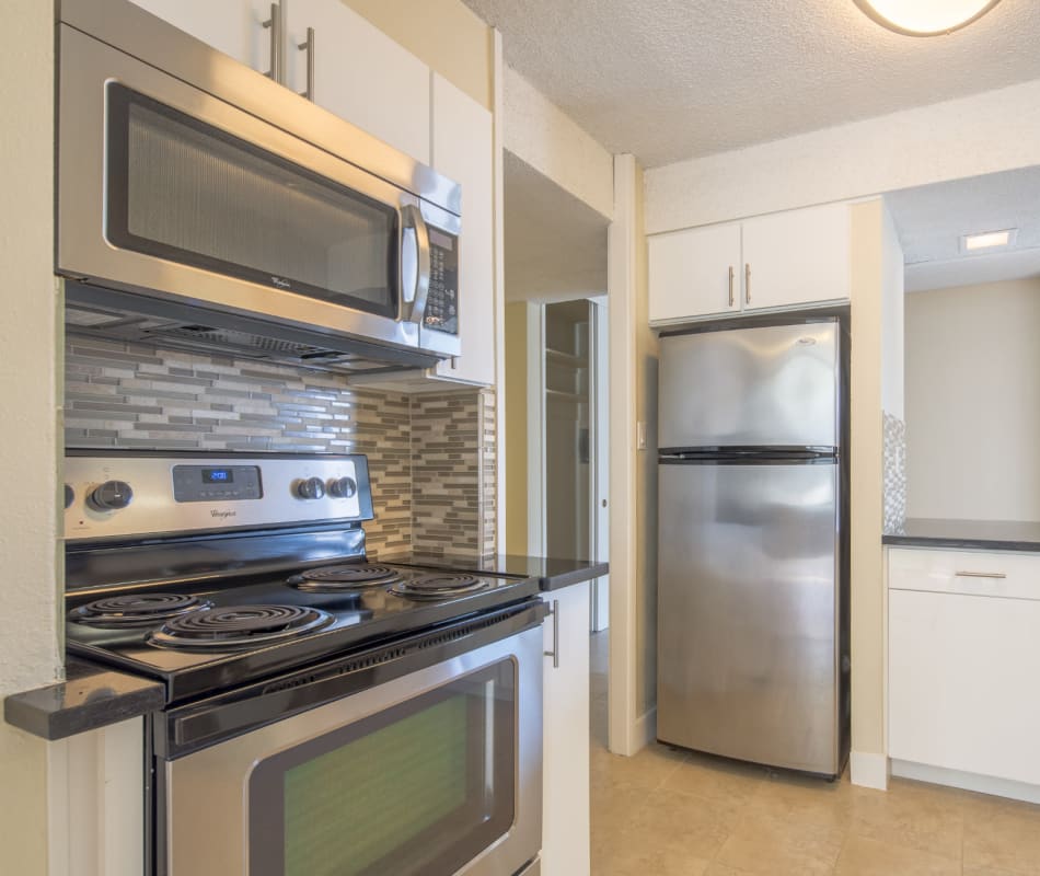 Modern kitchen with sleek, stainless-steel appliances in a model home at Skyline Terrace Apartments in Burlingame, California