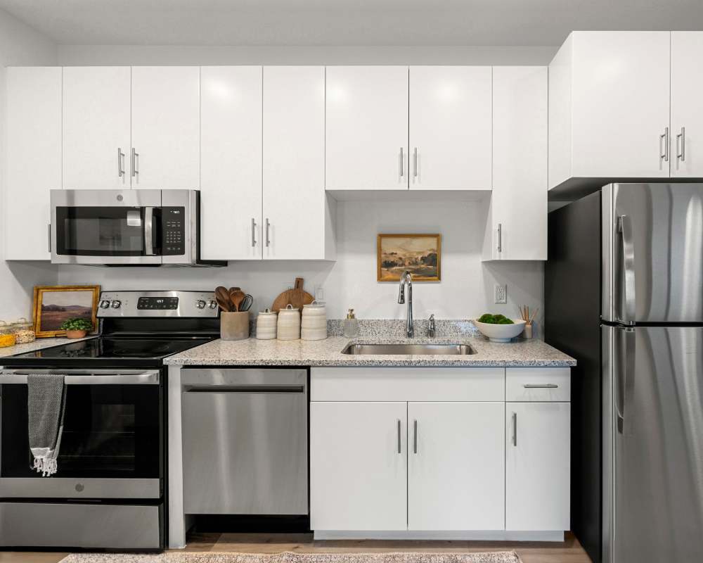 Rich, white color cabinetry and granite countertops in a model home's gourmet kitchen at Olympus at Arroyo Verde in Tucson, Arizona