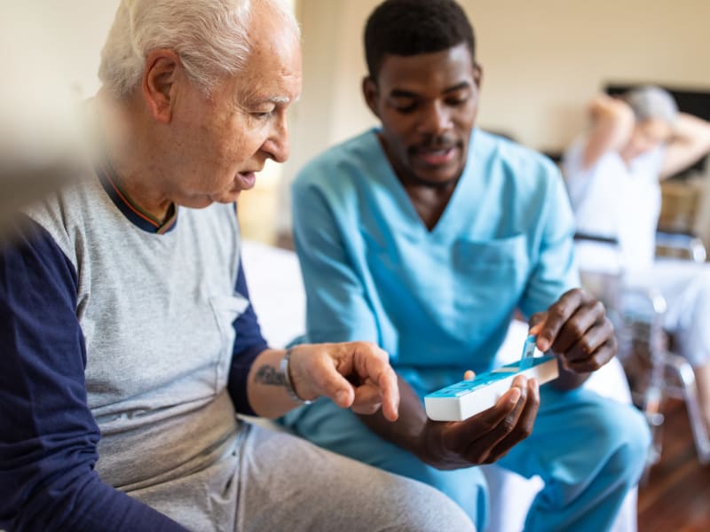 Resident getting assistance with medications at Geneva Lake Manor in Lake Geneva, Wisconsin