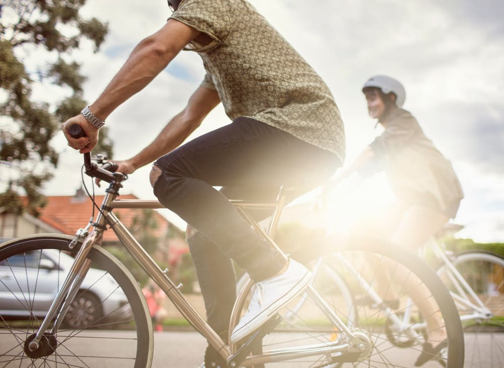 A couple riding bikes in Marina del Rey, California, on their way home to Harborside Marina Bay Apartments