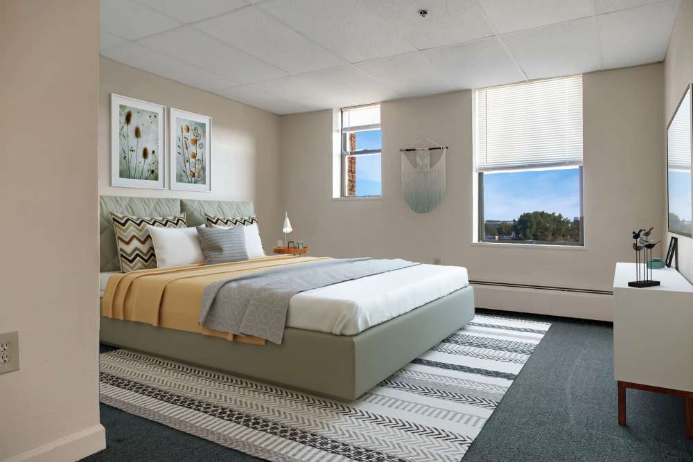 Bed with decorative pillows and artwork at The Majestic in Lowell, Massachusetts