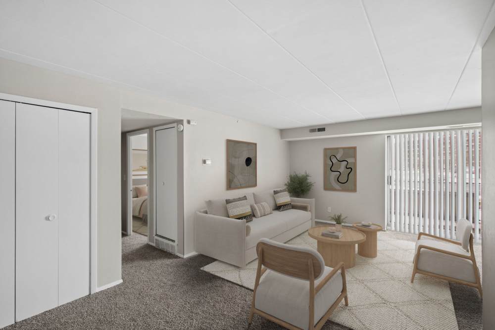 Spacious living area with comfortable seating, natural light, and sliding glass door at Granada Gardens Apartments in Warrensville Heights, Ohio
