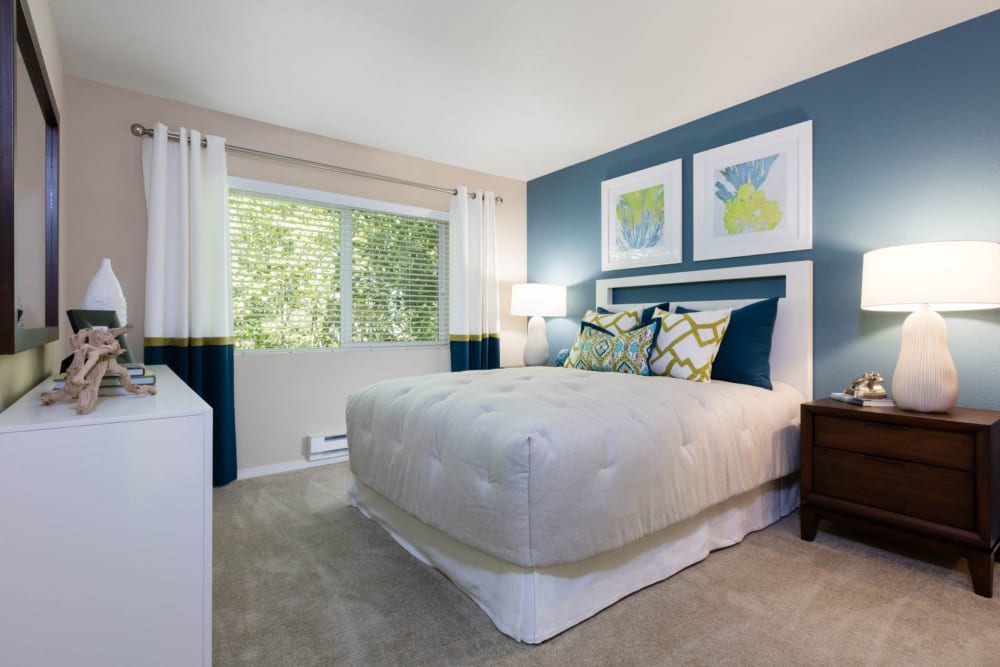 Master bedroom with draped windows and an accent wall in a model home at Haven at Golf Creek in Portland, Oregon