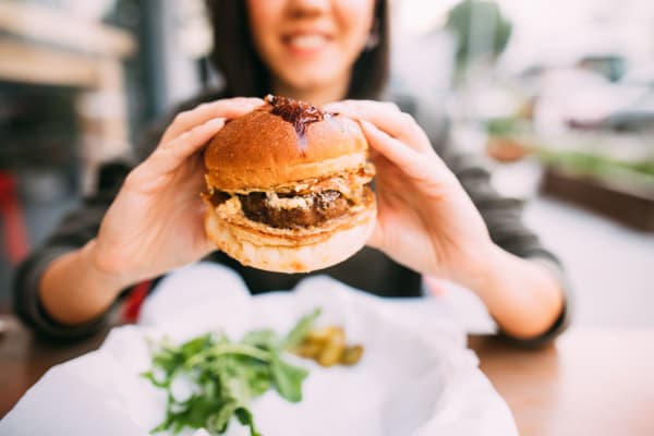 A resident eating a burger at a restaurant near Magnolia Gardens in Brookhaven, Georgia