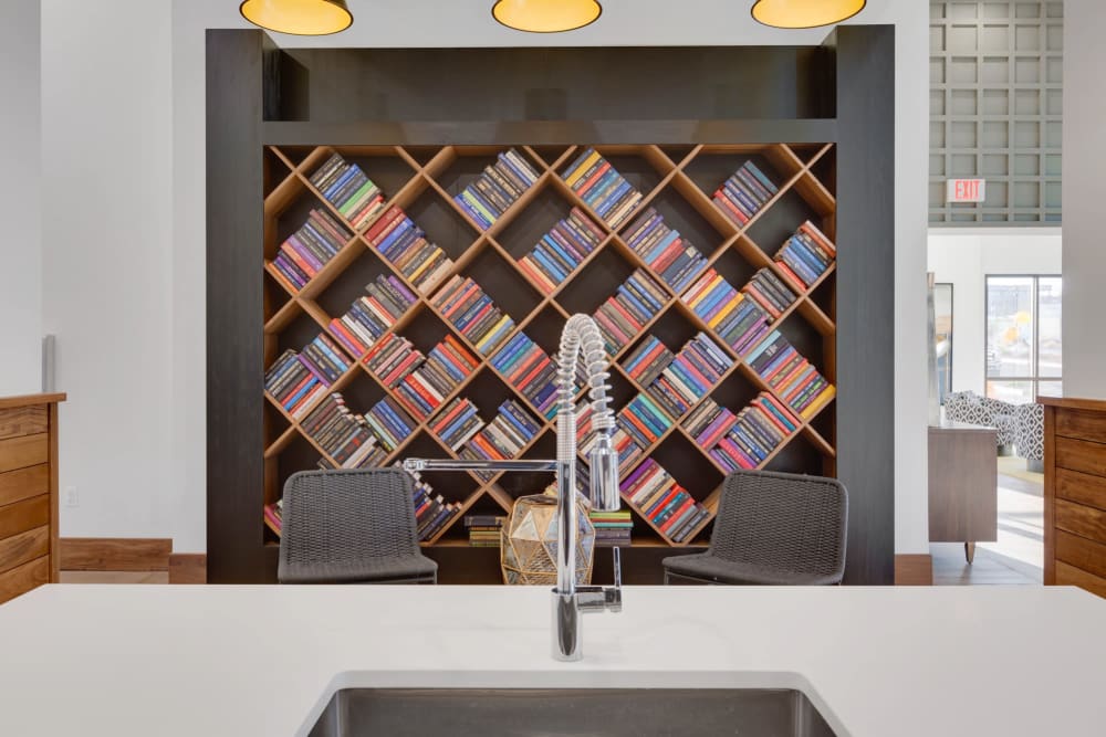 Community kitchen sink and wall of books at Olympus Highlands North in Albuquerque, New Mexico