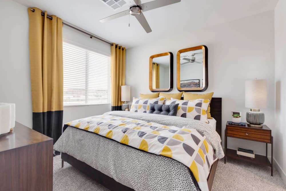 Model bedroom with a ceiling fan and plush carpeting at Olympus Highlands North in Albuquerque, New Mexico