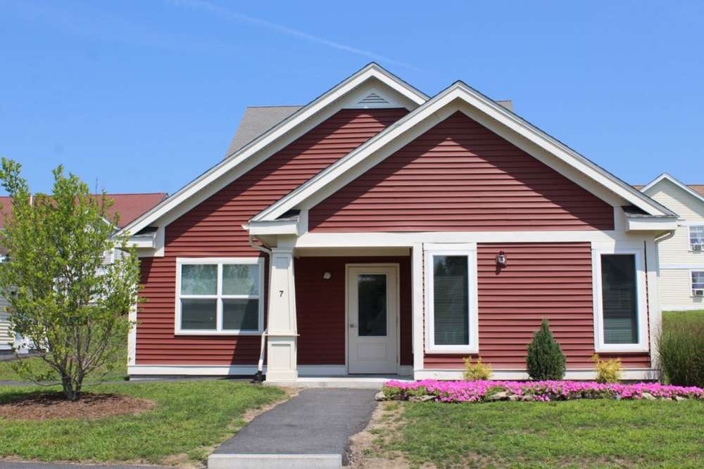Charming red exterior with landscaped garden at Stony Brook Village in Westford, Massachusetts