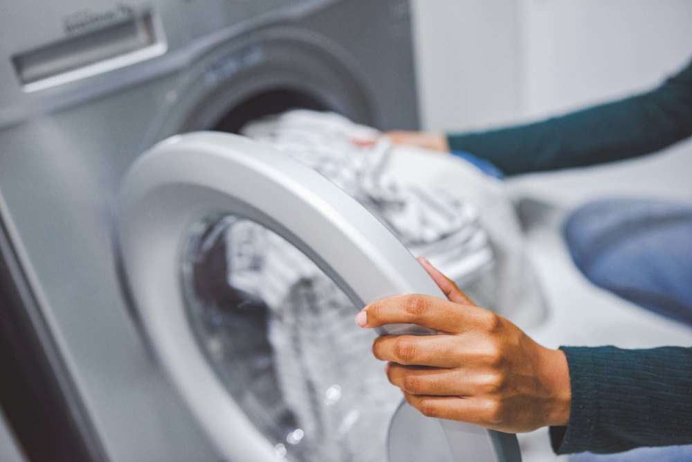 Resident using in-home washer and dryer at Canyon Townhomes in Phoenix, Arizona