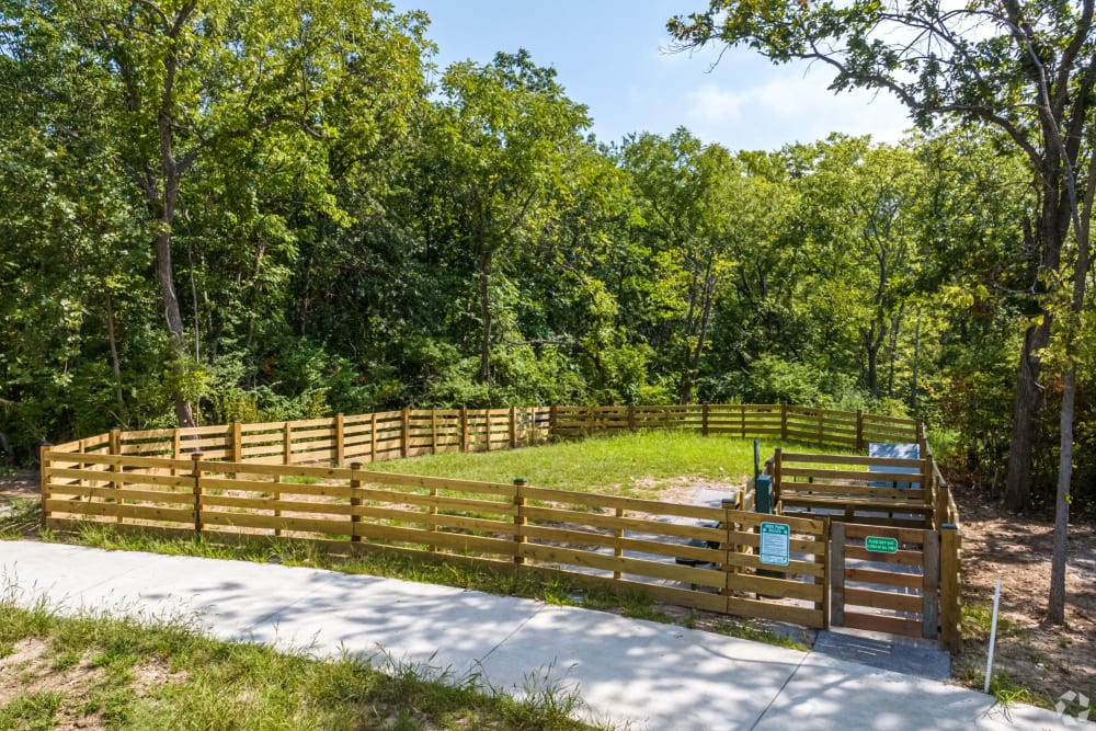 Apartments Kansas City MO for Rent - Forest Ridge Villas - Gated Dog Park with Grass Surrounded By Large Trees.