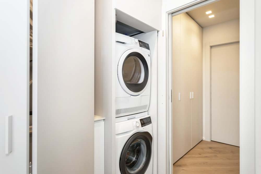 Laundry area with stacked washer and dryer at Apperson Way Apartments in Kokomo, Indiana