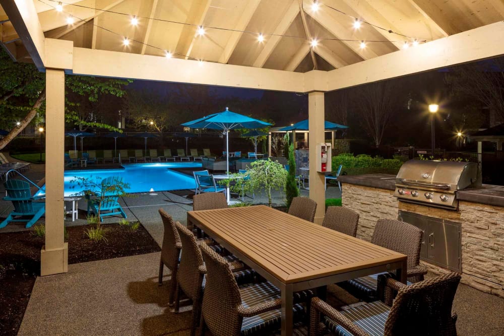 A grilling area by the pool at dusk at The Grove at Orenco Station in Hillsboro, Oregon