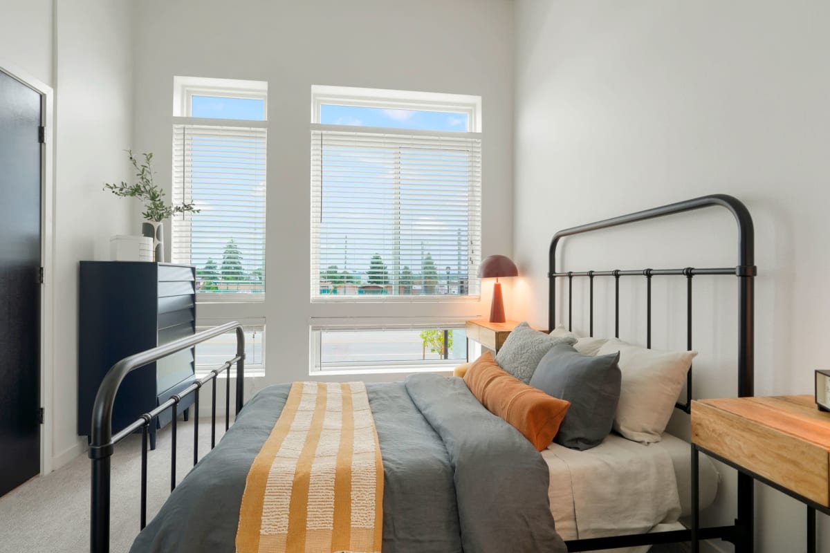 Apartment bedroom with bright windows at The Parallel in Wheat Ridge, Colorado