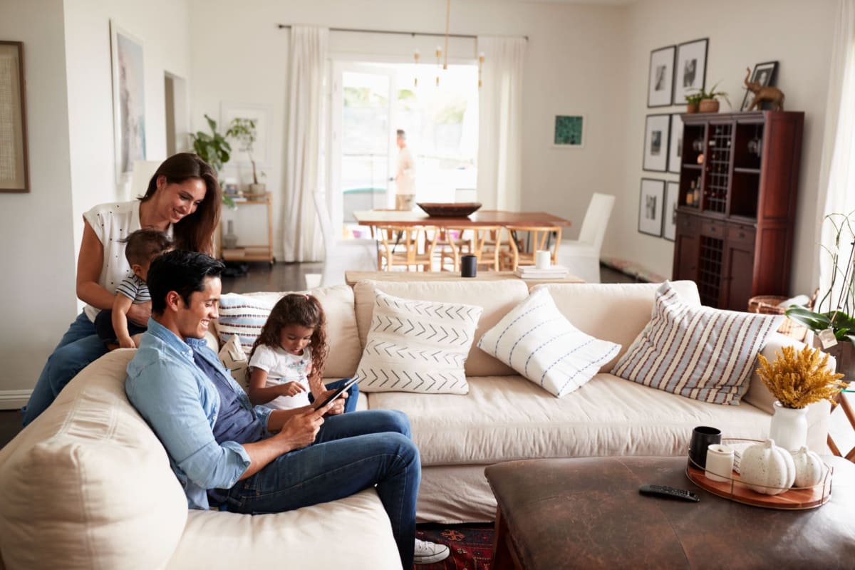 A family gathers around the sofa in their apartment at Kaitlin Court, Los Angeles, California