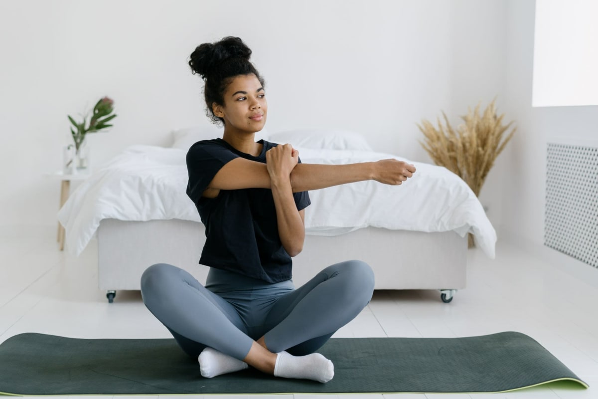 A resident stretches on a yoga mat in her apartment at The Howard, Glendale, California